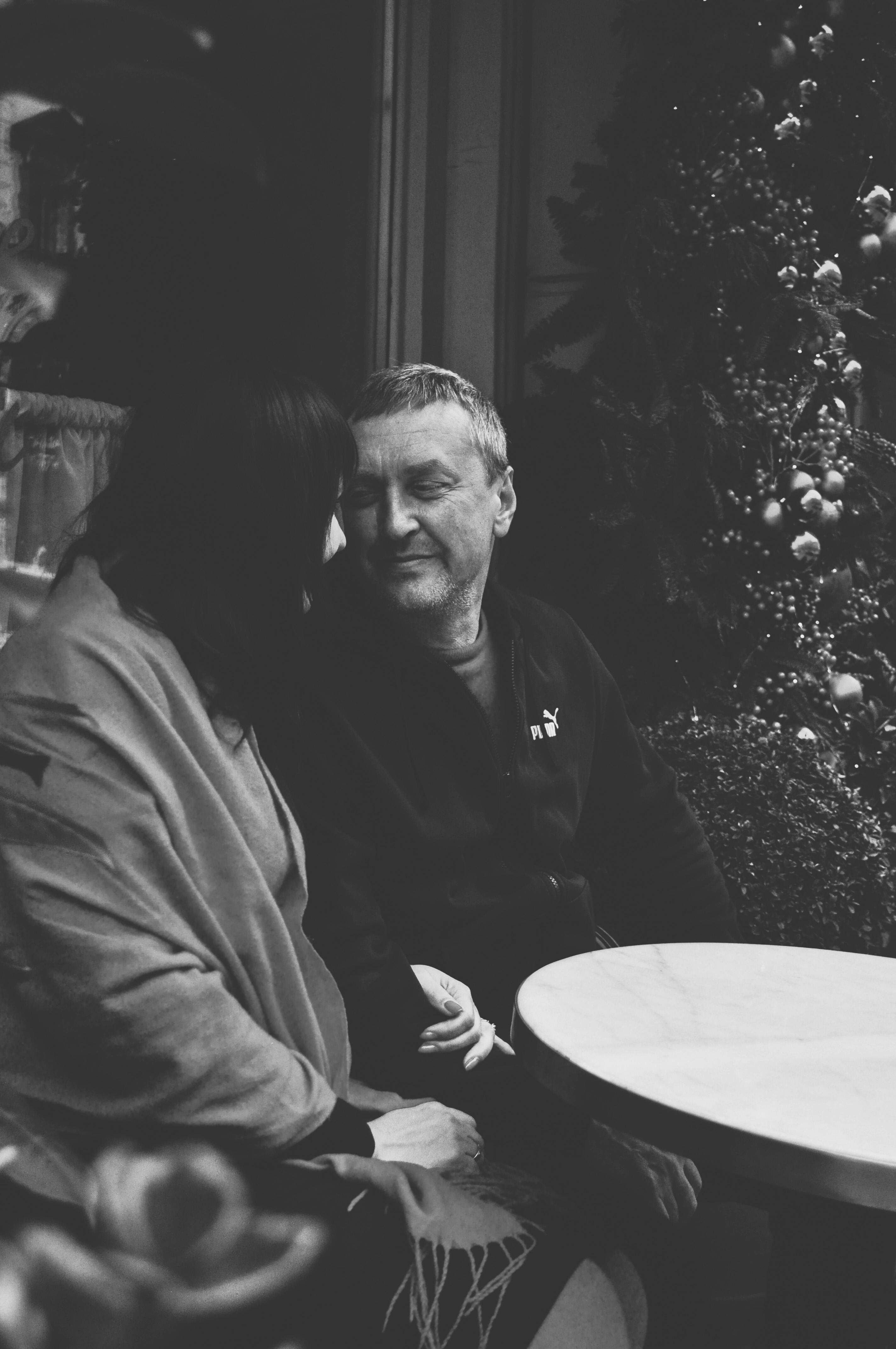 ingyenes Őszinte pillanat egy párról, akik együtt töltik az időt egy hangulatos kávézóban, fekete-fehérben megörökítve. Stockfotó