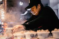 在北京繁忙的市场街道上，亚洲街头小贩煮着传统饺子