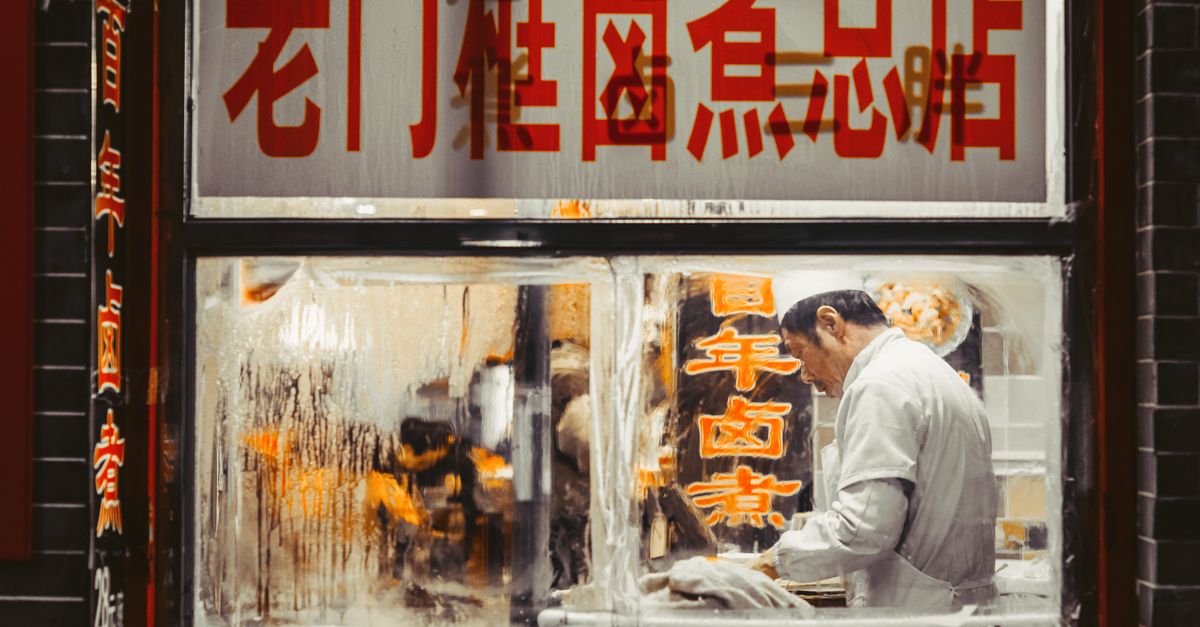 Chef working in a traditional Beijing restaurant kitchen, showcasing authentic Chinese cuisine.