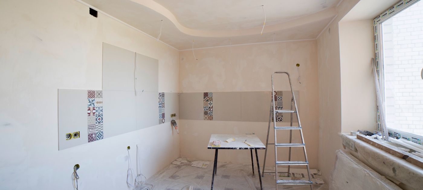 A kitchen under renovation with a ladder and tools — the stage just before pest control should be booked
