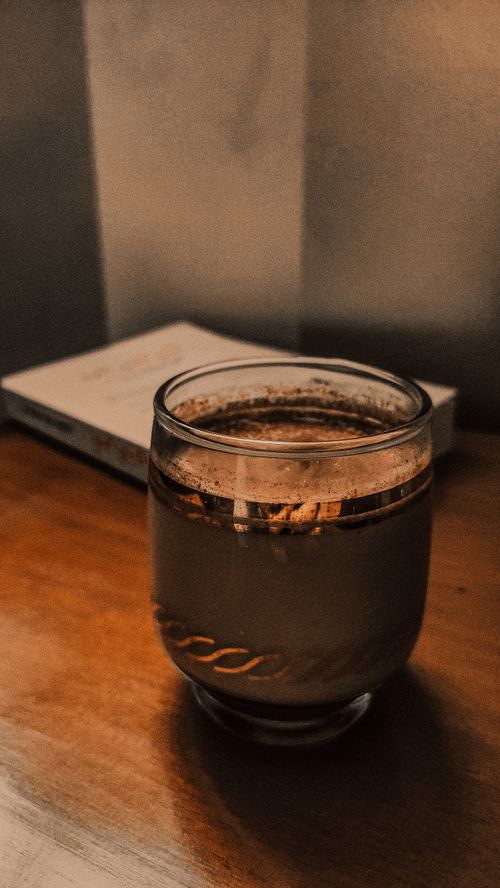 Free A cozy glass of coffee on a warm wooden table capturing a vintage aesthetic. Perfect for lifestyle and home themes. Stock Photo
