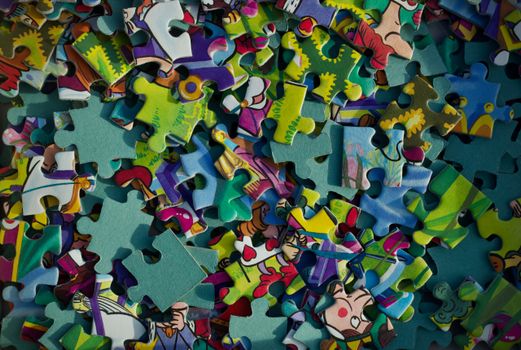 Vivid close-up of colorful jigsaw puzzle pieces scattered randomly.
