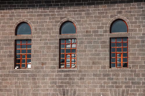 Free A close-up view of three arched windows on a historic stone building facade in Diyarbakır, Türkiye. Stock Photo