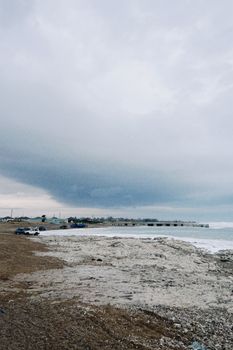 A stormy sky over a rocky beach in Konaev, Kazakhstan, showcasing natural beauty.