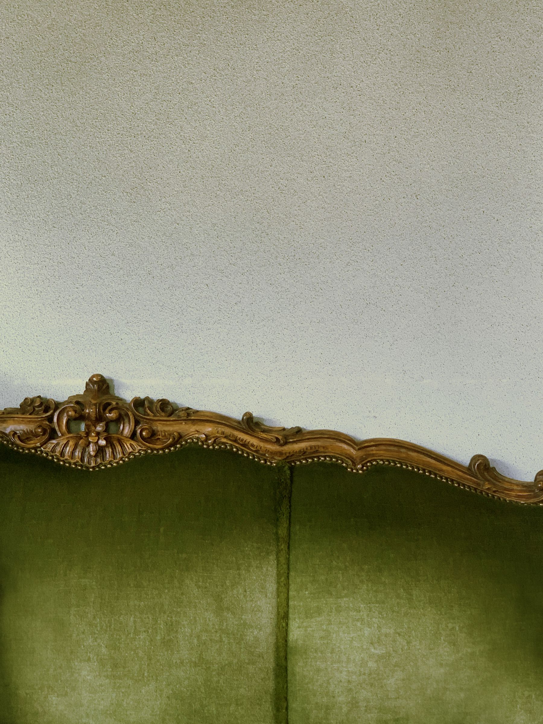 Tailored green upholstery with piping and a substantial traditional profile