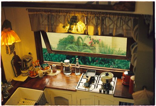 Warm and inviting vintage kitchen interior featuring a garden view through the window.