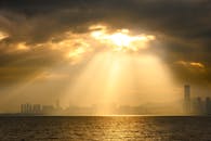 Sunrays Over City Skyline at Sunset