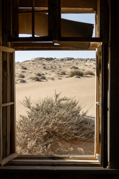 Free A desert landscape framed by an old window in Namibia's arid environment. Stock Photo