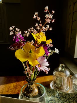 室内阳光照射下，花瓶里插着一束色彩缤纷的鲜花