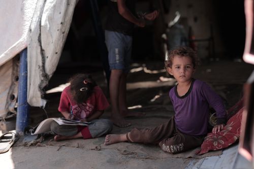Free Two children inside a tent in Gaza, engaging in daily activities. Captured with a Canon EOS R6. Stock Photo