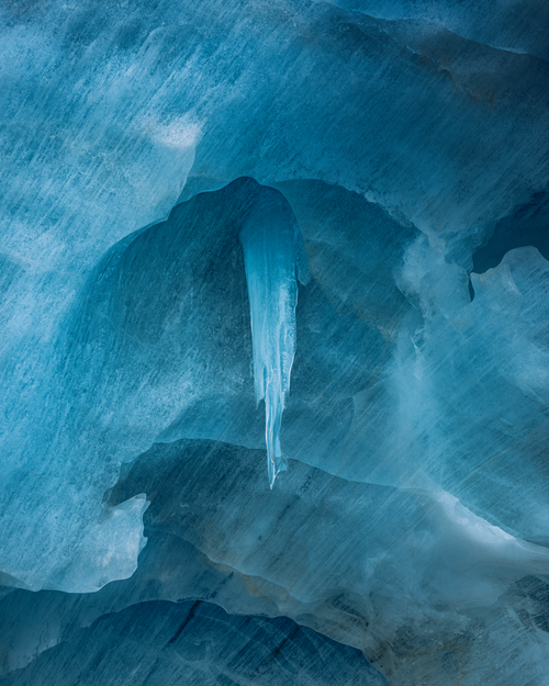 Free Stunning blue ice cave interior with a prominent icicle formation. Stock Photo