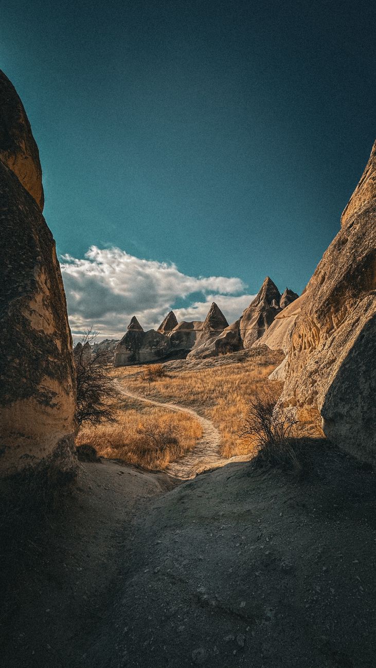 Captivating landscape of unique rock formations in Cappadocia, Türkiye under a bright blue sky.