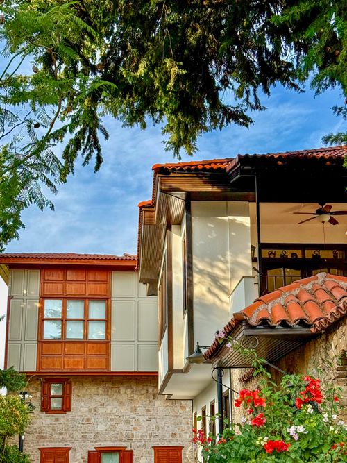Free Traditional architecture of a house in Antalya, Türkiye surrounded by lush greenery. Stock Photo