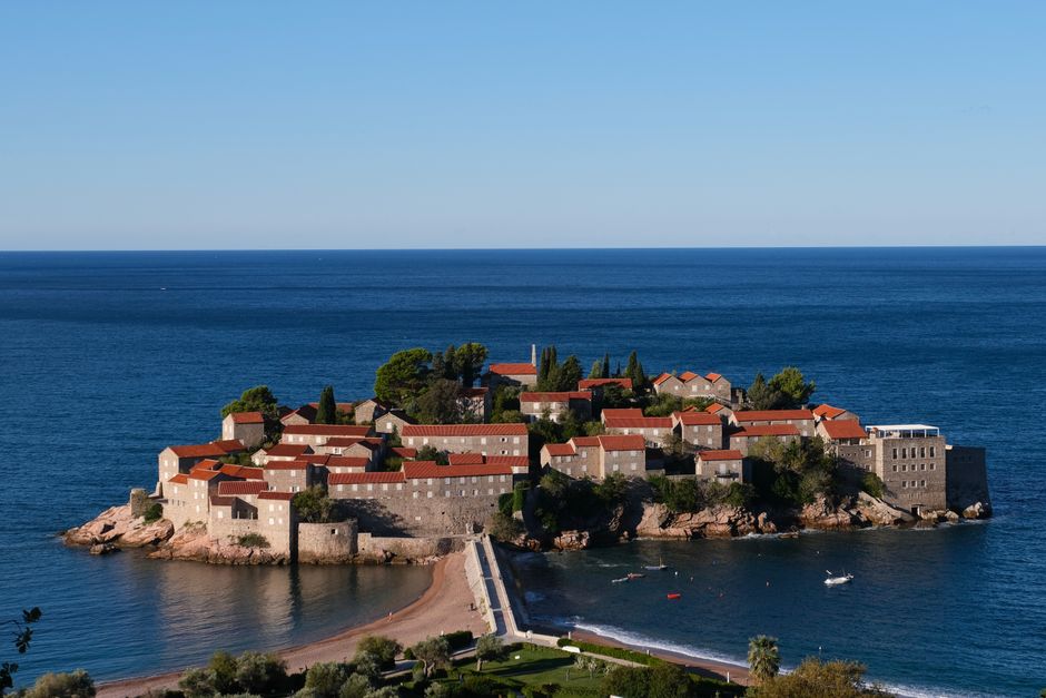 Vista aérea deslumbrante da ilha Aman Sveti Stefan, Montenegro, com suas construções históricas e mar azul.