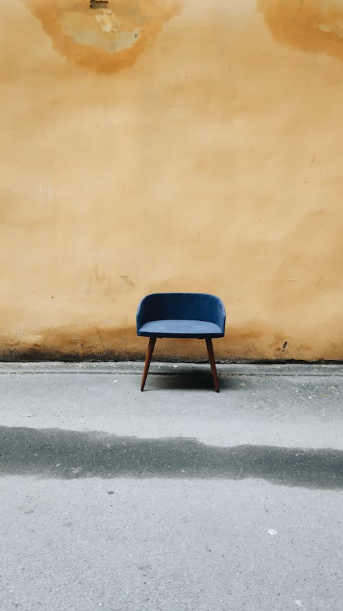 茶色の壁の横にある青と黒の椅子
