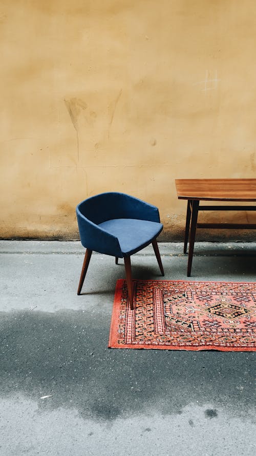 Una Silla Azul Y Una Mesa De Madera En Una Habitación