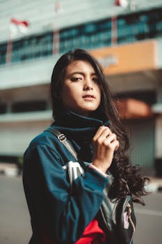 一位时尚女性穿着蓝色夹克，站在城市外面