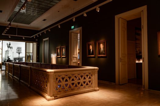Beautiful art gallery interior featuring classic portraits and sculptures in dim lighting.