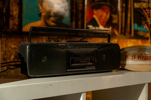A classic boombox on a shelf surrounded by vintage posters, evoking nostalgia.