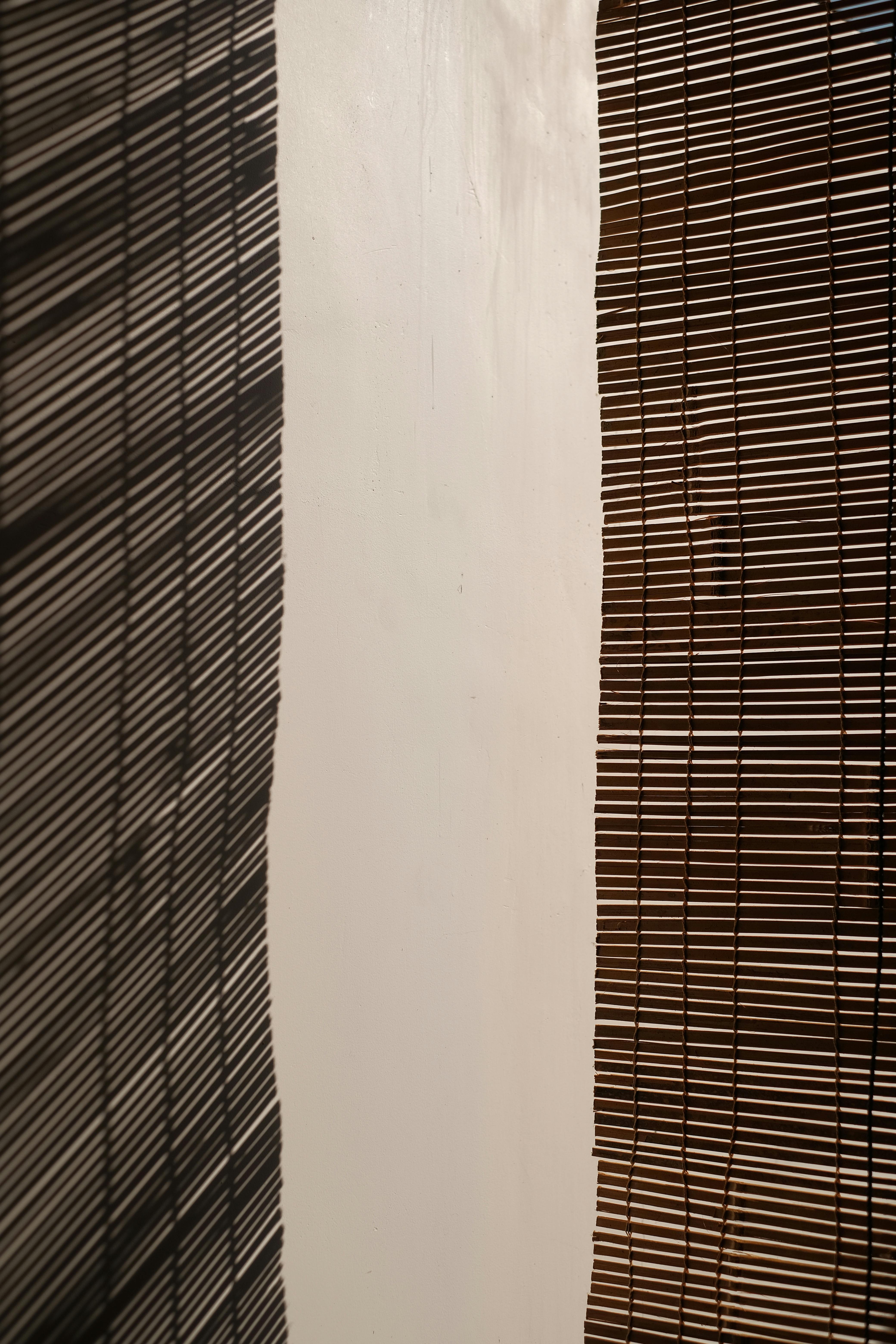 Gratuit Le jeu artistique de la lumière et des ombres sur les stores à rayures crée un effet visuel abstrait. Photos