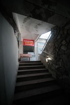 Atmospheric view of a concrete staircase leading to an urban passageway with Vietnamese signage.