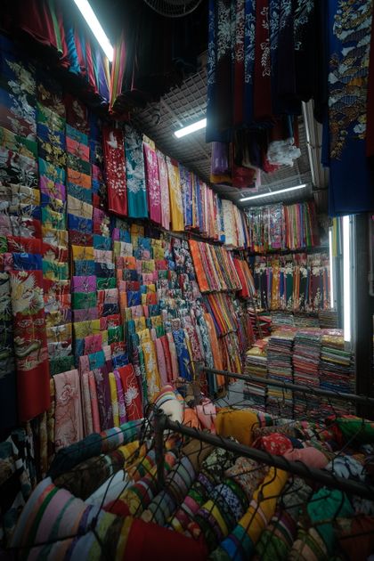 Cuộn vải polyester màu sắc trưng bày tại cửa hàng vải sỉ — chọn nhà cung cấp vải polyester uy tín