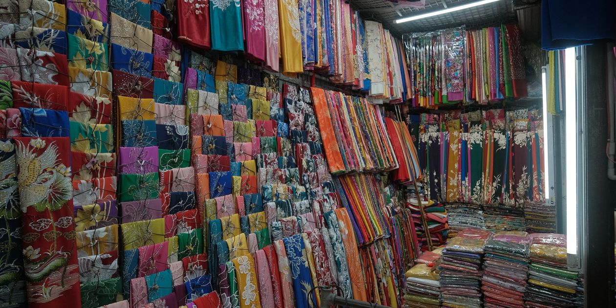 Cuộn vải polyester màu sắc trưng bày tại cửa hàng vải sỉ — chọn nhà cung cấp vải polyester uy tín