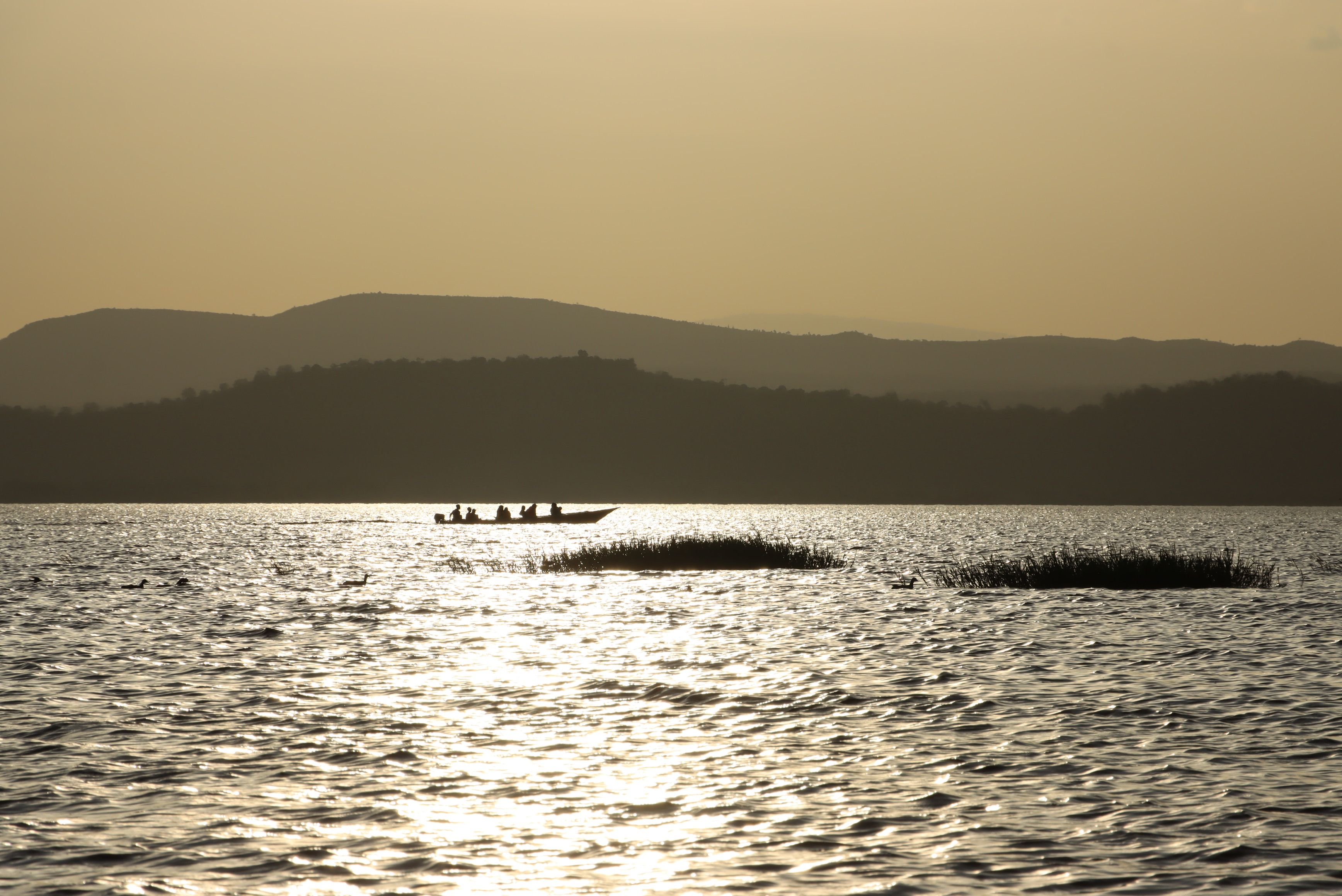 Tranquil Sunset Boat Silhouette on Lake · Free Stock Photo