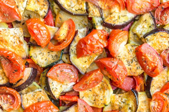 Close-up of roasted eggplant and zucchini rounds with blistered tomatoes and dried thyme
