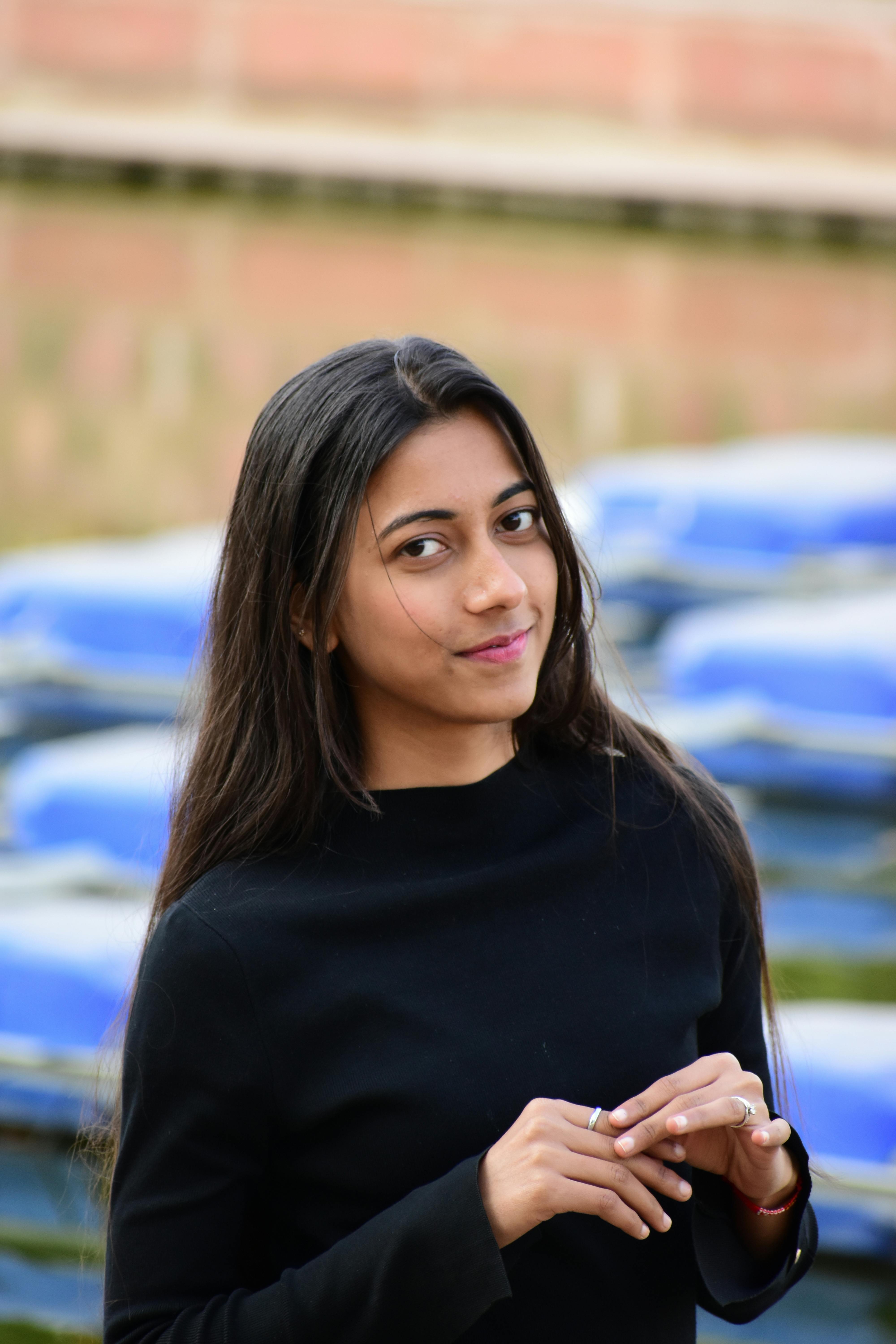 Beautiful young woman with long hair posing outdoors with blurred background.