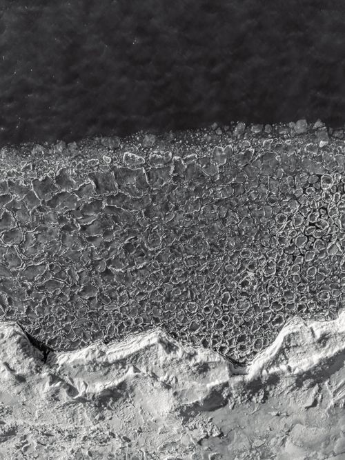Free A stunning aerial shot of Chicago's Lake Michigan shoreline covered in ice during winter. Stock Photo