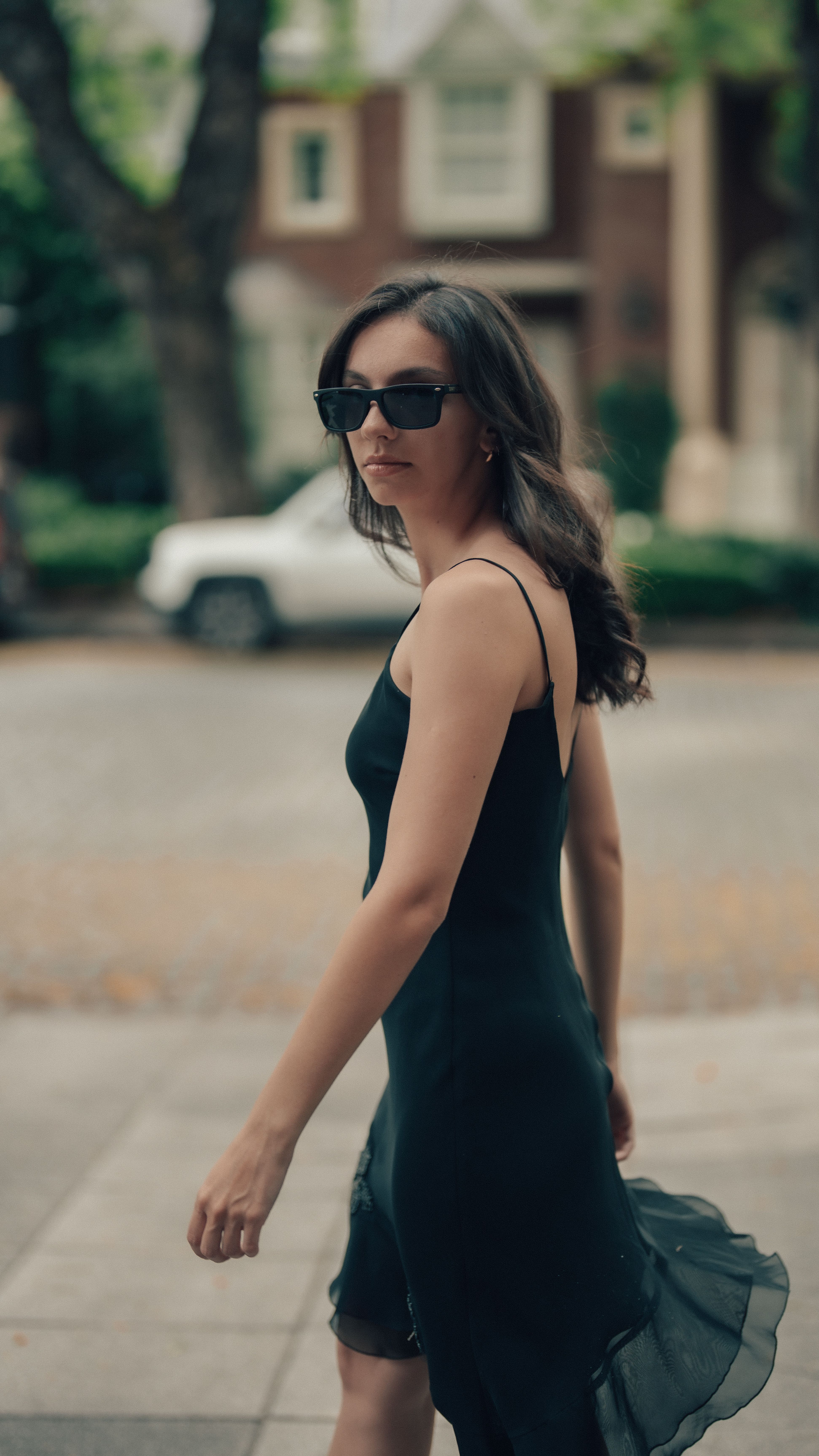 Stylish Woman in Black Dress Walking Outdoors · Free Stock Photo
