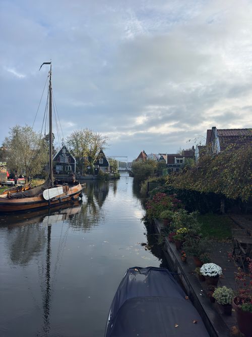 Free Picturesque Dutch canal with traditional boats and charming houses on a cloudy day. Stock Photo