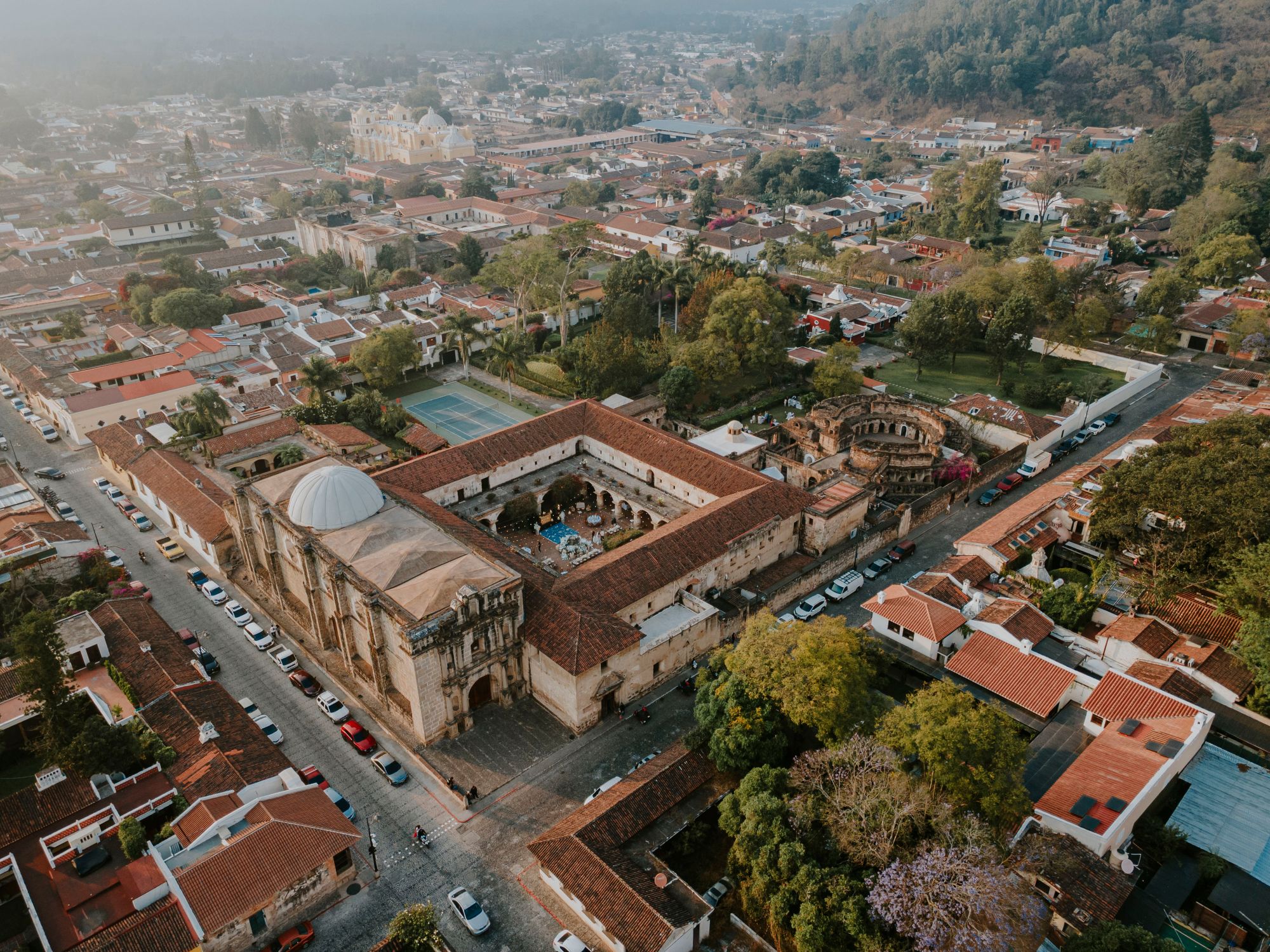 Discover the rich colonial architecture of Antigua Guatemala from above, showcasing vibrant streets and historic landmarks.