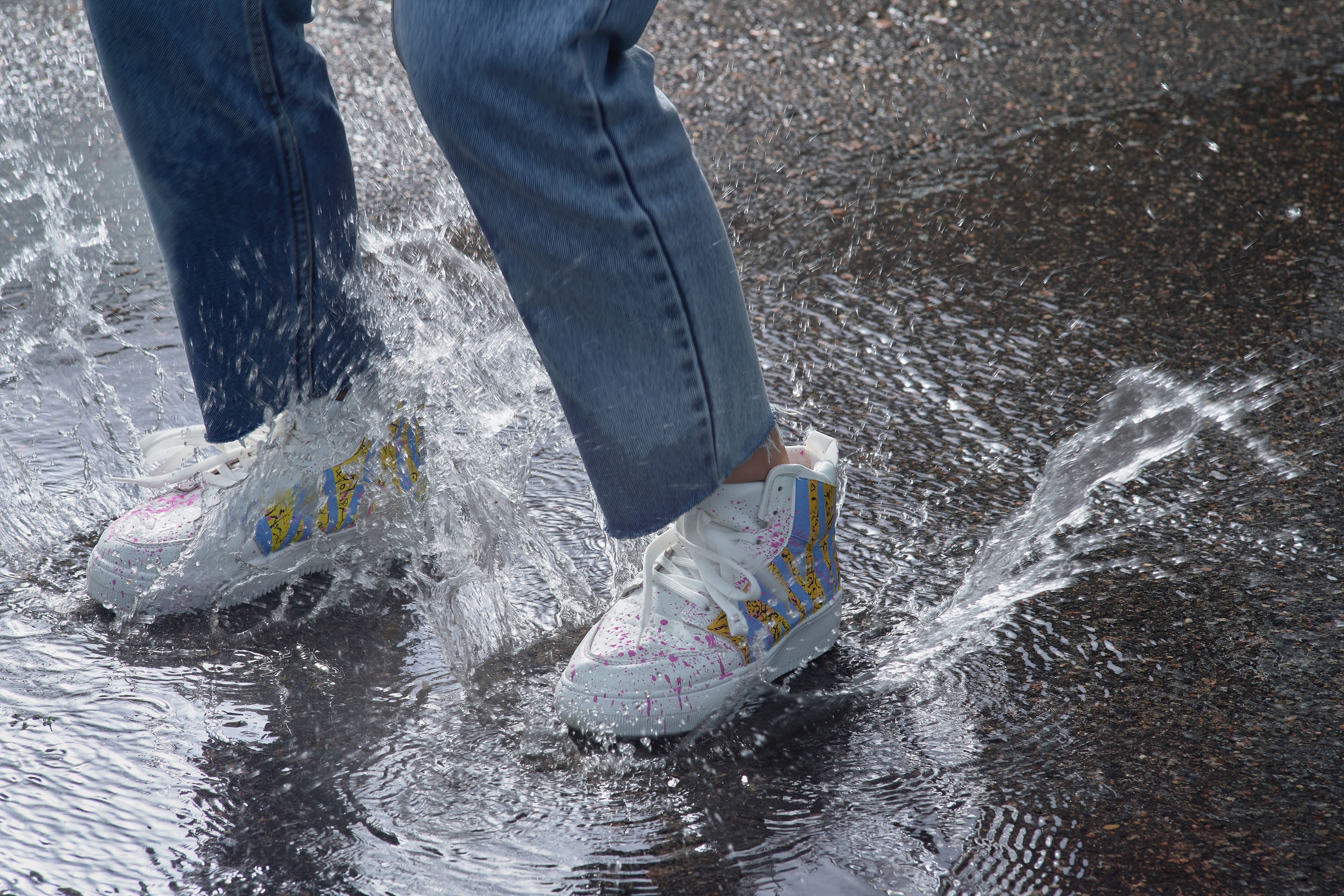 Close-up of sneakers splashing in a puddle · Free Stock Photo