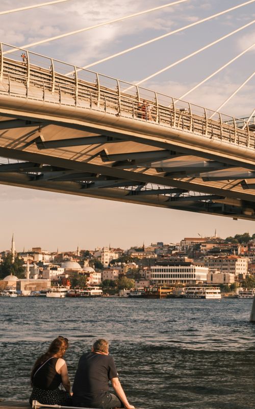 Free A couple gazes at the Istanbul skyline under a modern bridge during the day. Stock Photo