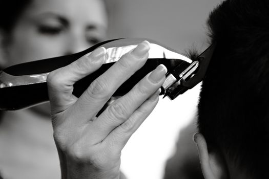 A close-up shot of a person receiving a haircut with electric clippers.