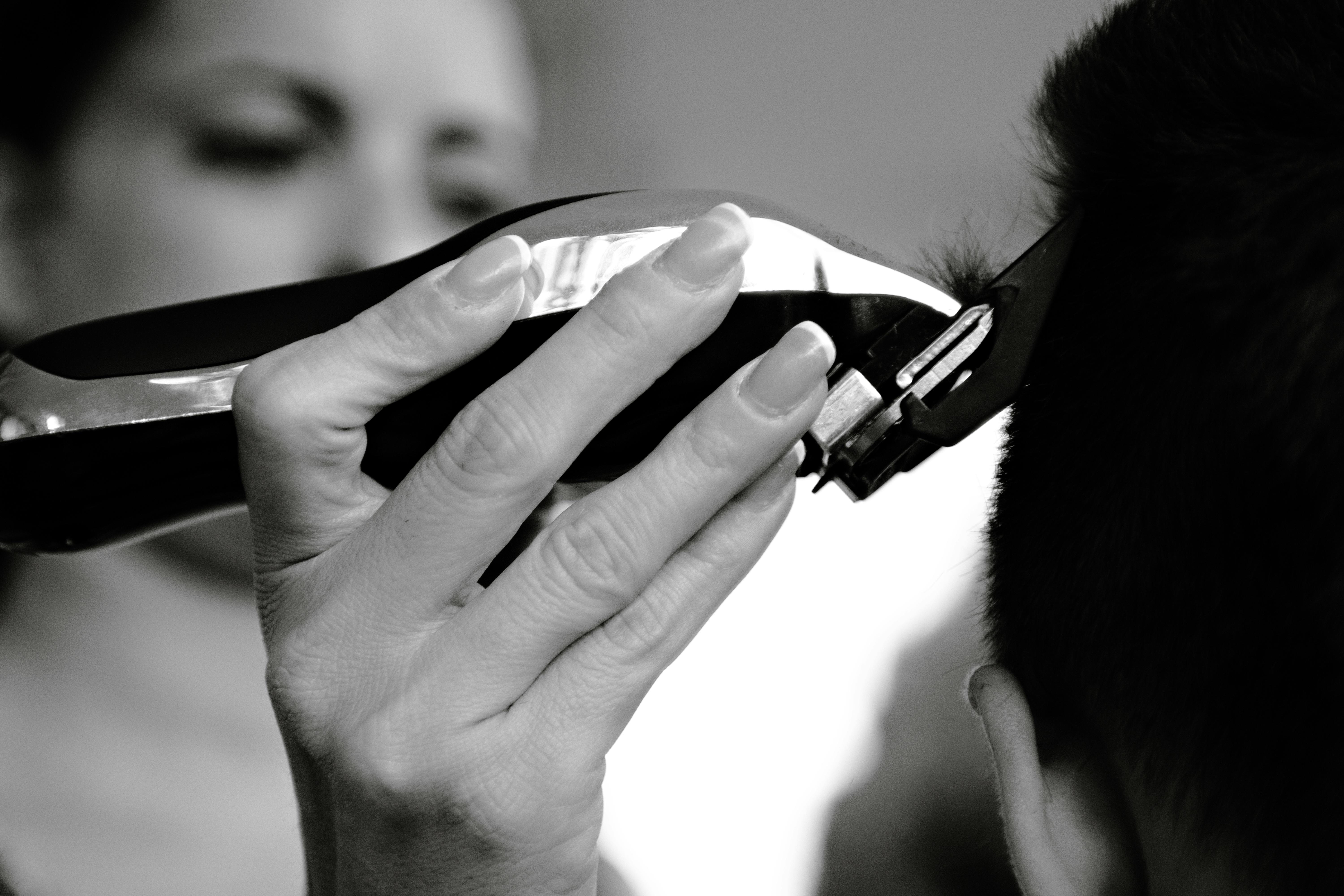 Gratis Primo piano di una persona che si taglia i capelli con un tagliacapelli elettrico. Foto a disposizione