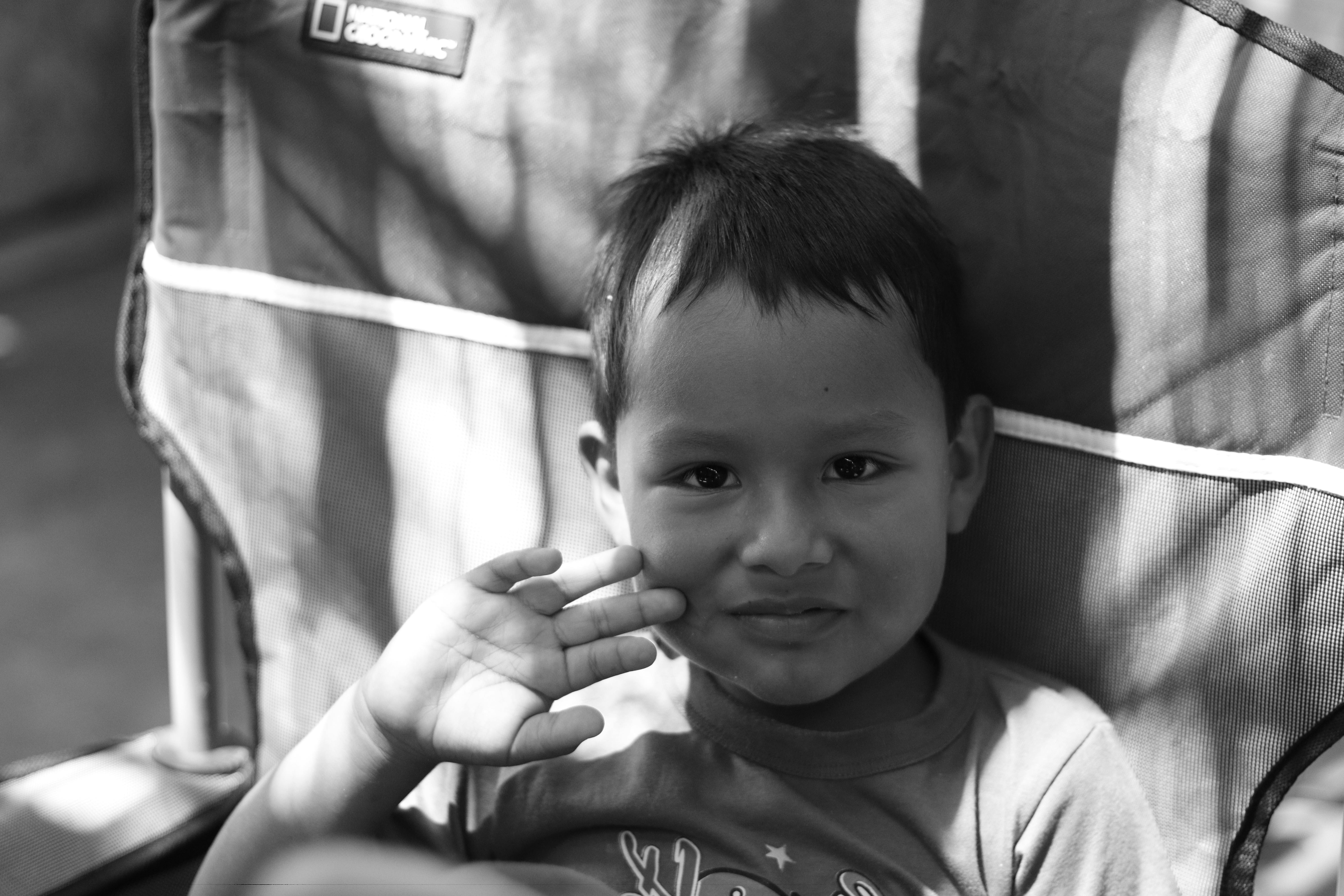 ingyenes Bájos fekete-fehér portré egy fiatal fiúról, aki mosolyog bent. Stockfotó