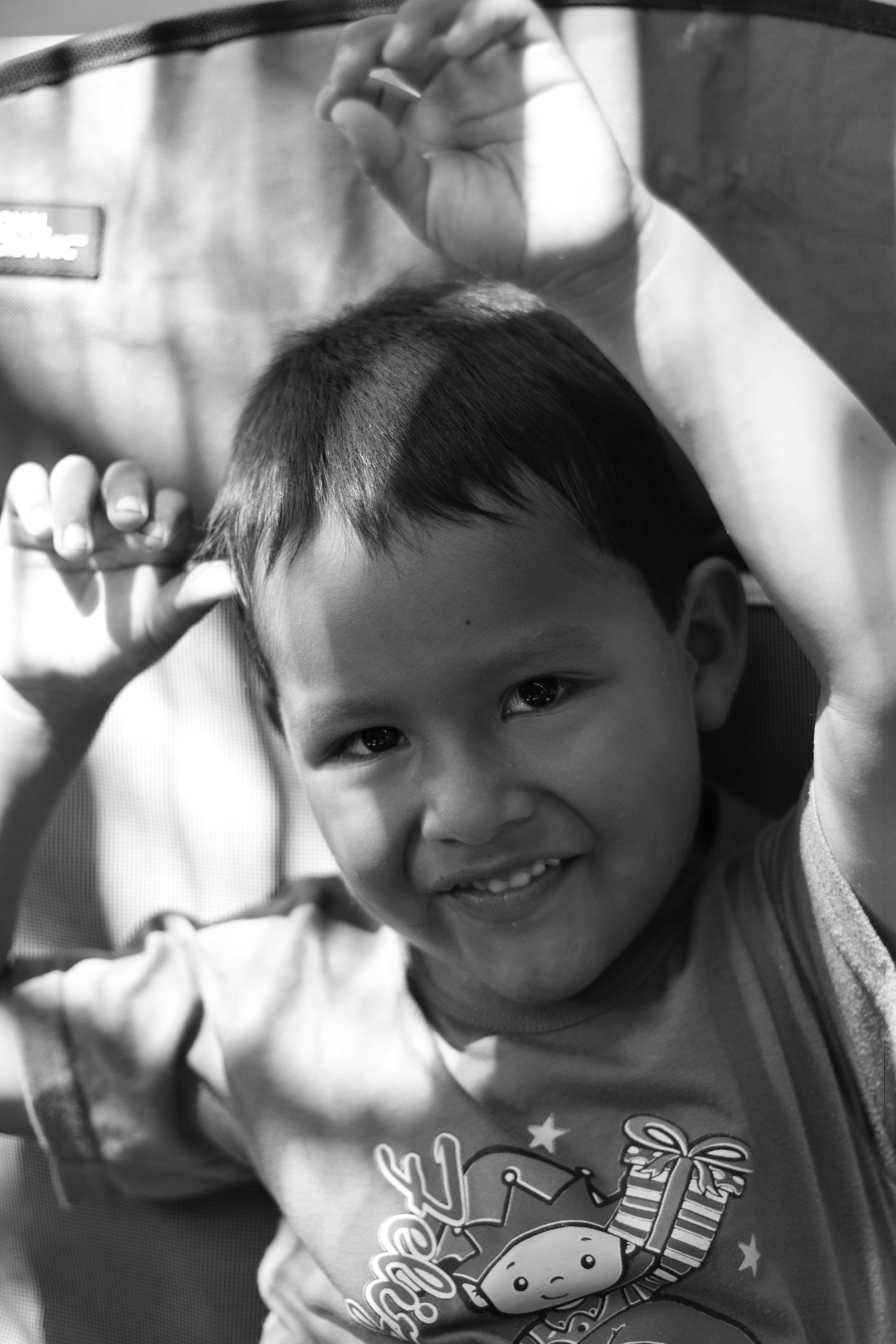 Δωρεάν Γοητευτικό ασπρόμαυρο πορτρέτο ενός ευτυχισμένου παιδιού που απολαμβάνει το φως του ήλιου στη Λίμα. Φωτογραφία από στοκ φωτογραφιών