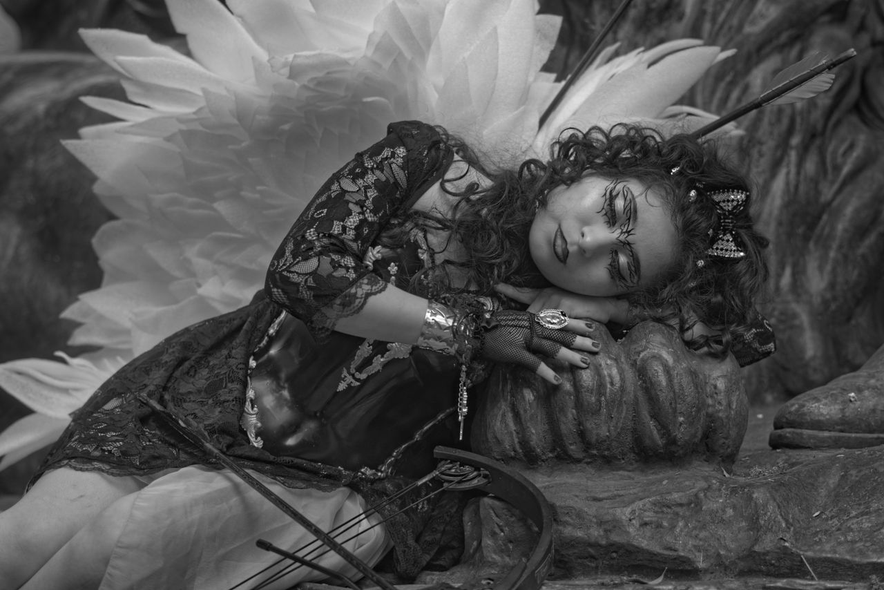 a whimsical fairy in elaborate costume rests in a serene pose capturin