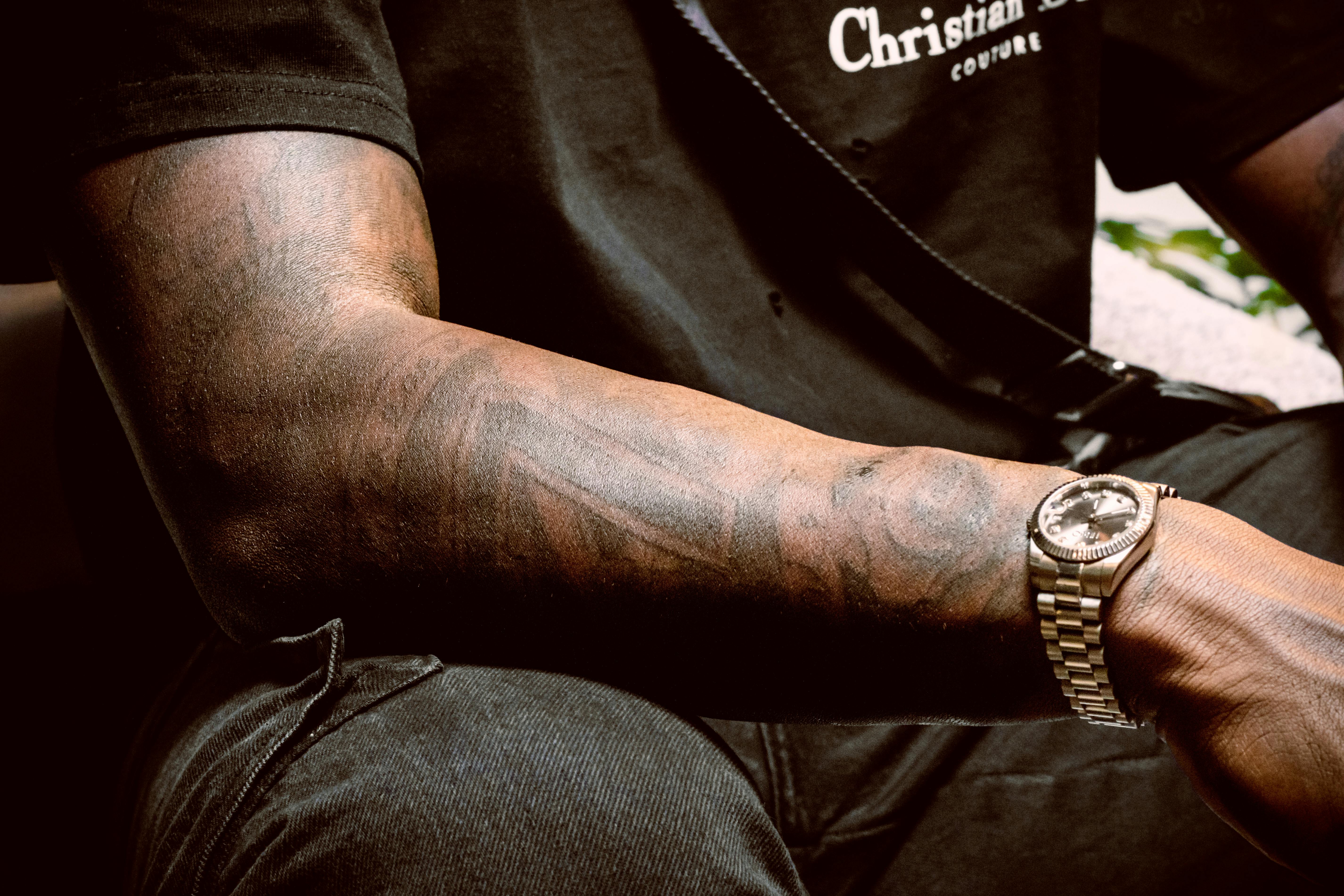 Free Detailed view of a tattooed arm wearing a luxury watch, showcasing intricate body art and style. Stock Photo