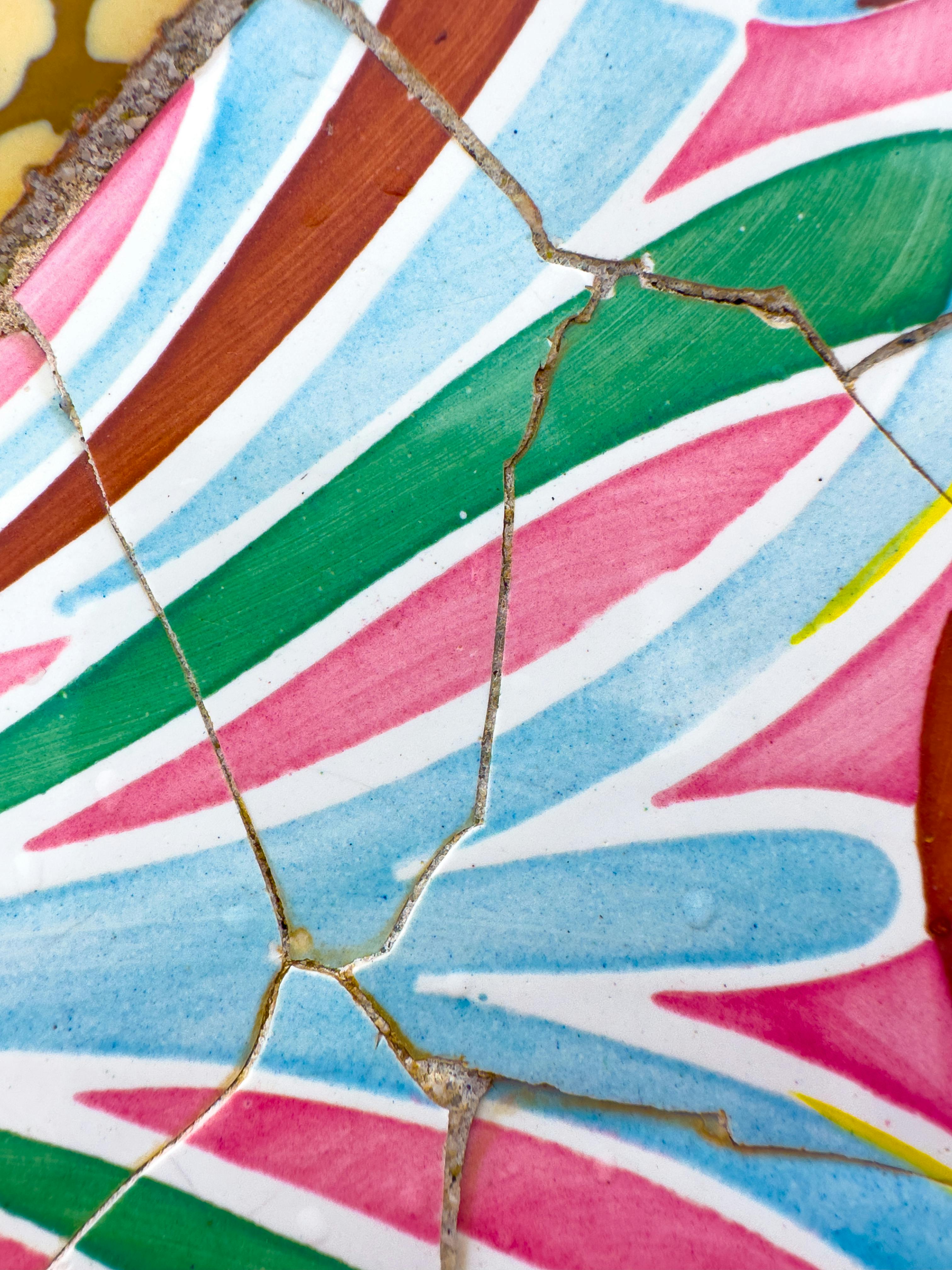 無料 グエル公園の壊れた陶器のモザイクの鮮明なクローズアップ。ガウディの芸術的なデザインが際立っています。 写真素材