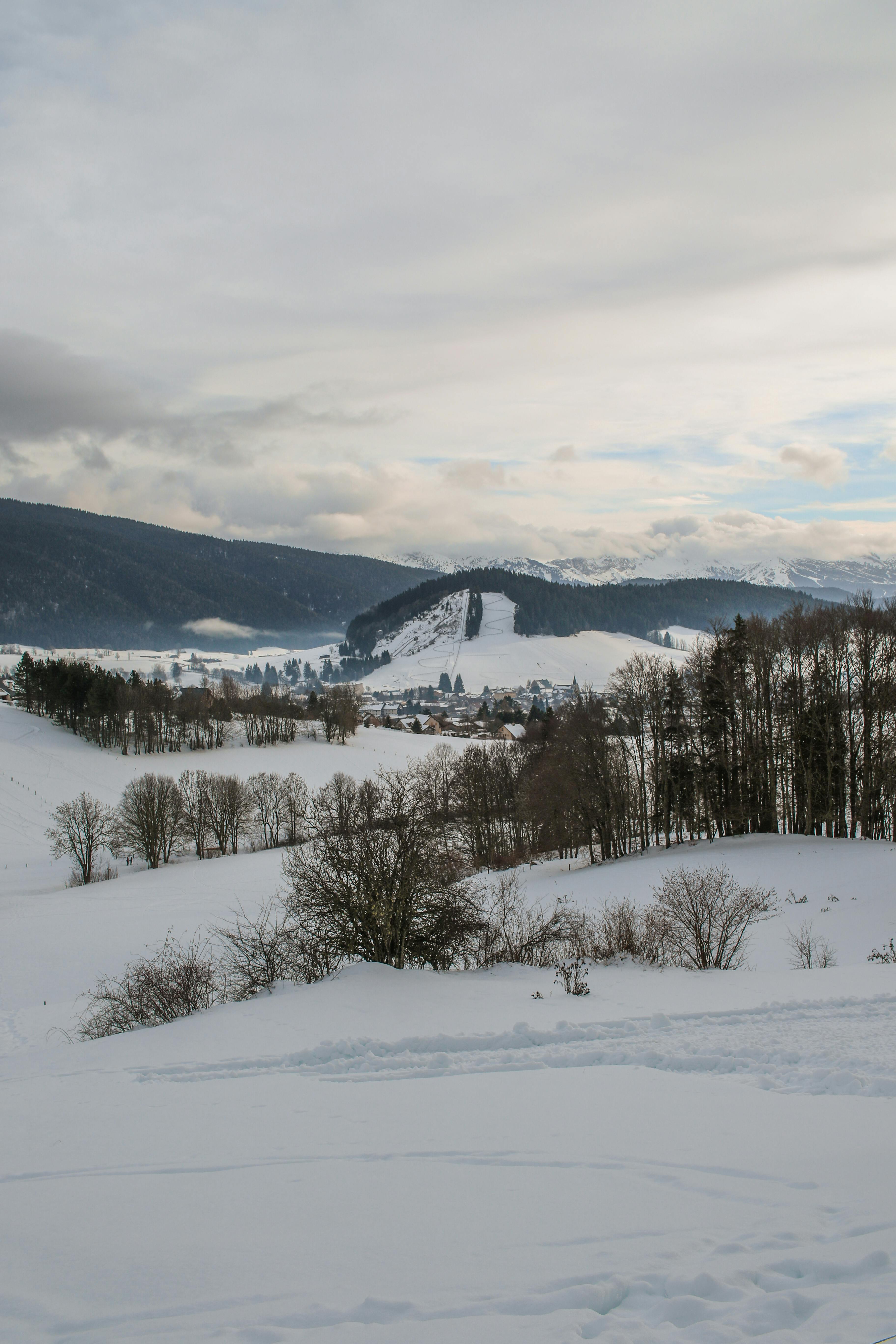 Scenic winter view of snow-covered hills in Autrans-Méaudre-en-Vercors, France.