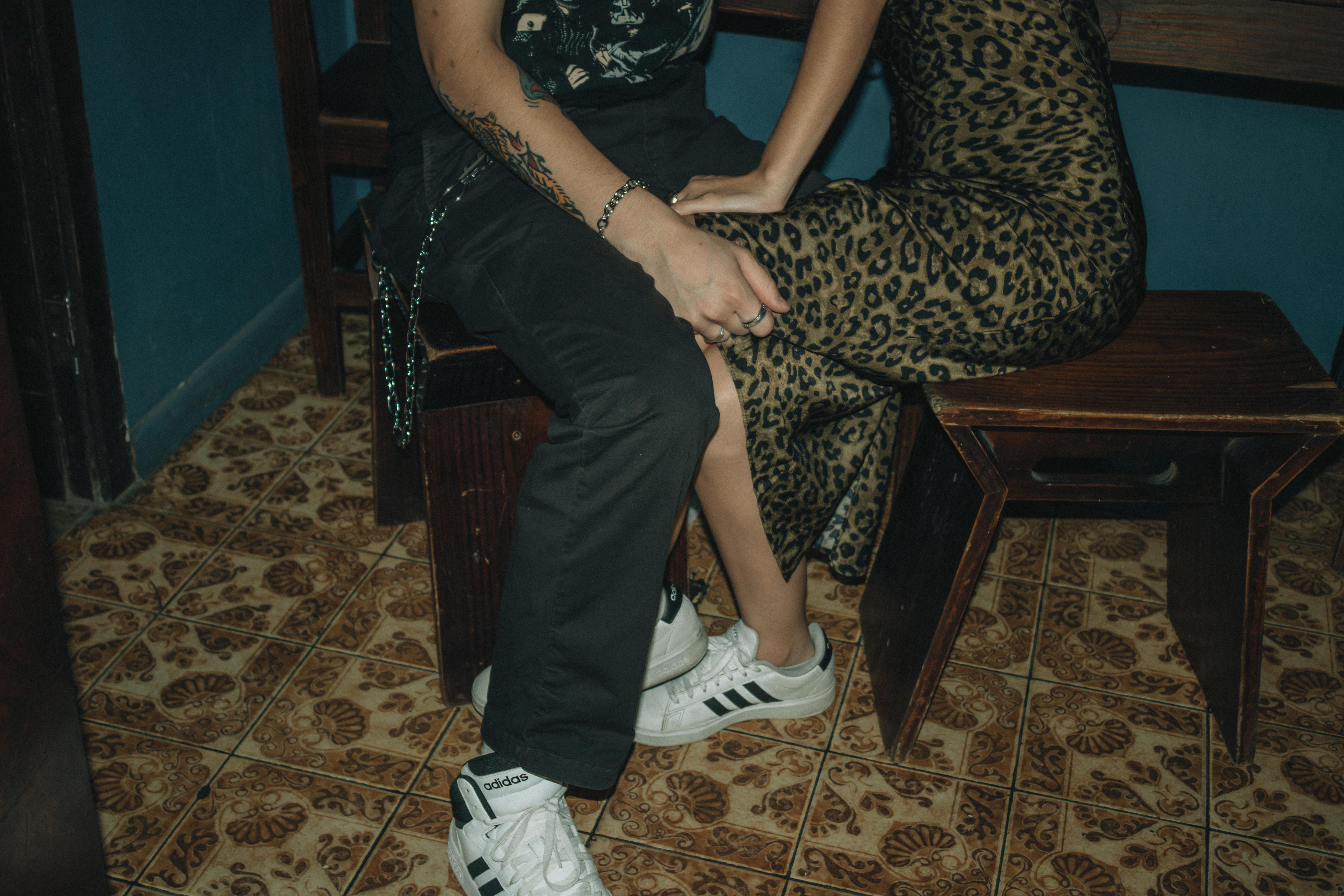 Gratuit Prim-plan cu două persoane așezate într-o cameră confortabilă, expunând modă și tatuaje. Fotografie de stoc