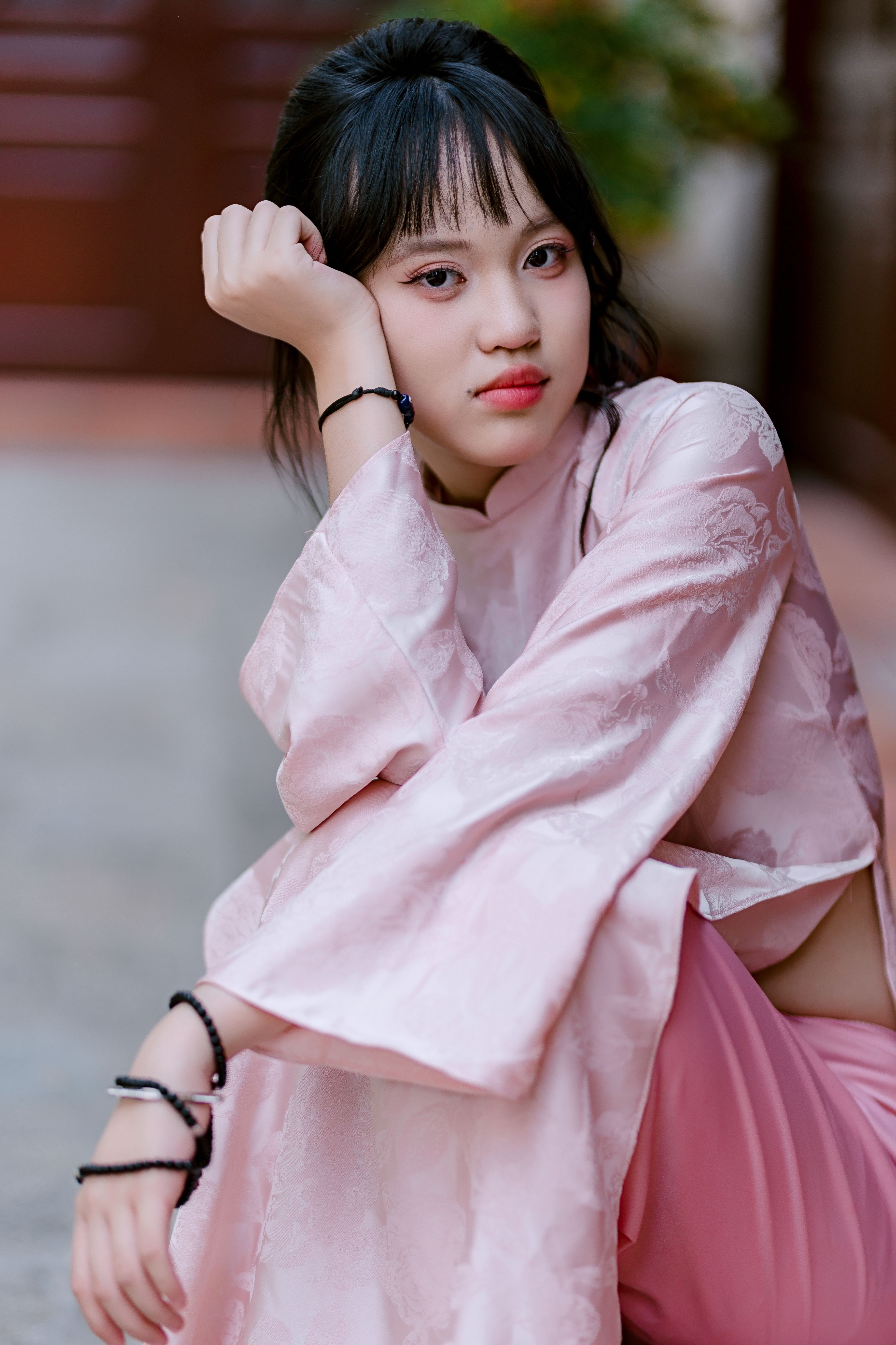 Portrait of a young woman in pink traditional dress, exuding elegance and calm.