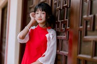 Young Woman in Traditional Red Attire by Ornate Wall
