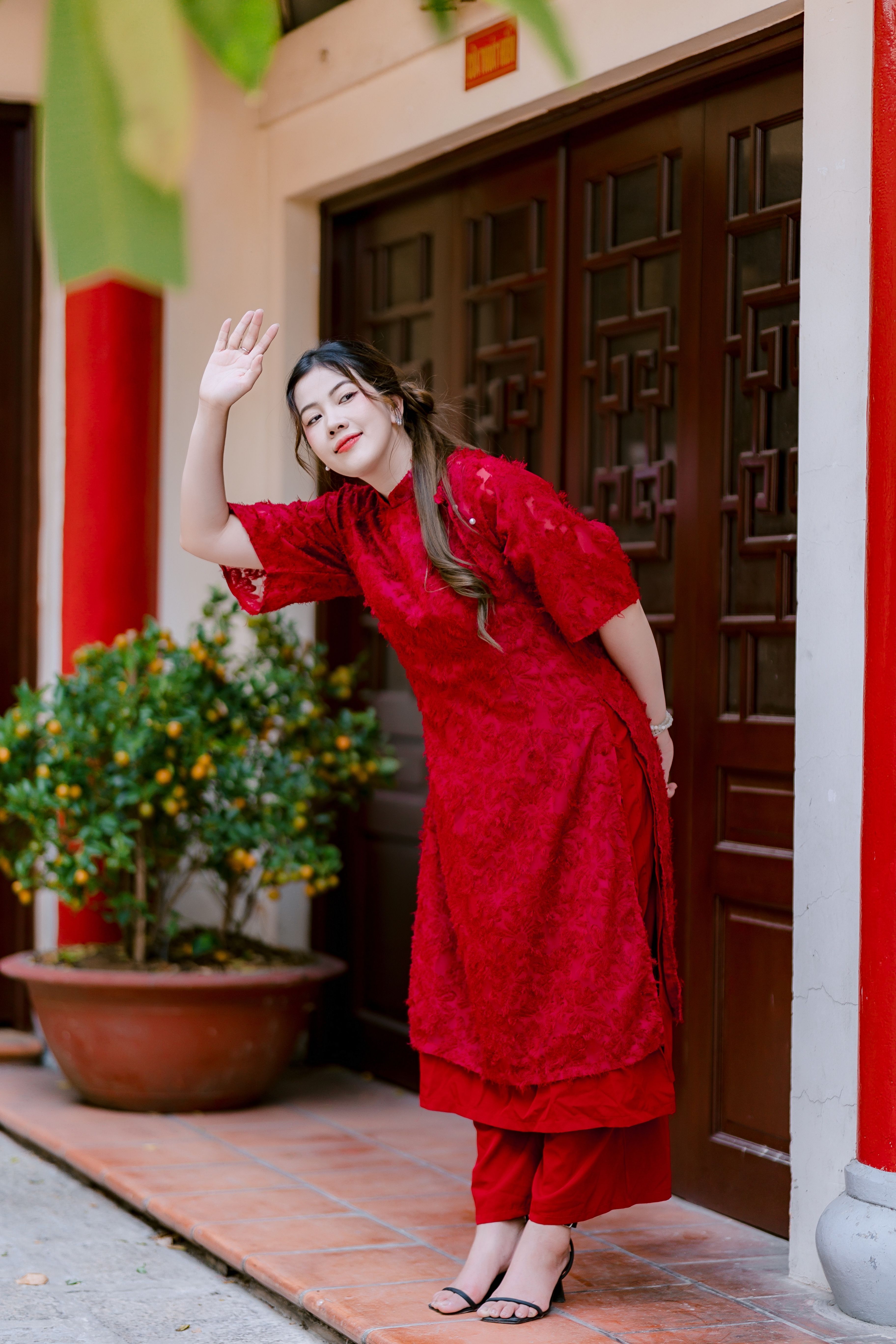 Woman in Traditional Red Attire Greeting Outdoors · Free Stock Photo