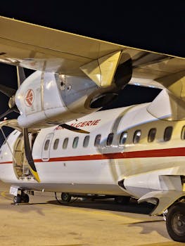 A detailed view of an Air Algerie airplane parked outdoors at night.