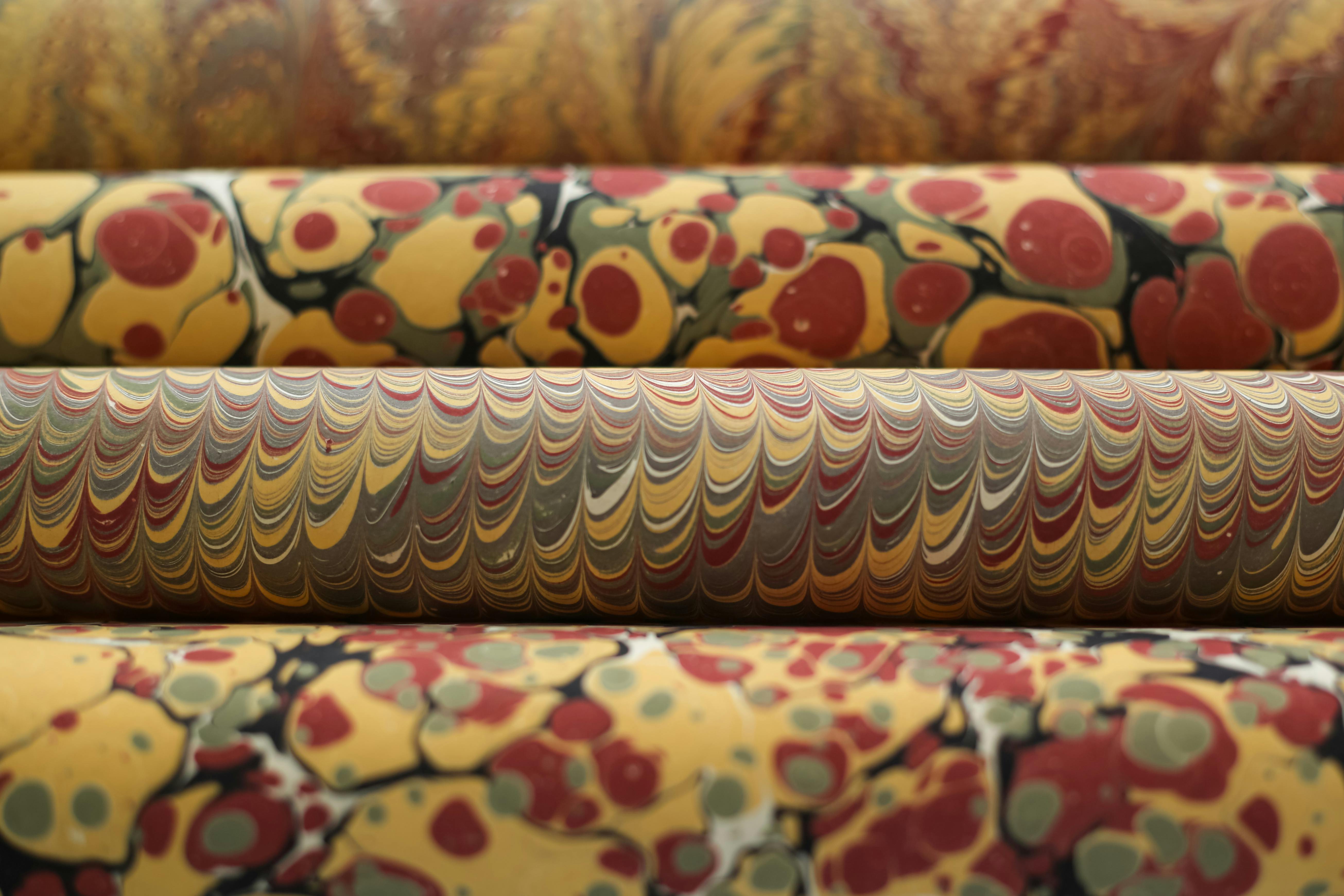 Δωρεάν Κοντινό πλάνο ζωηρών μαρμάρινων χαρτιών σε ρολά που παρουσιάζουν περίπλοκα σχέδια και χρώματα. Φωτογραφία από στοκ φωτογραφιών